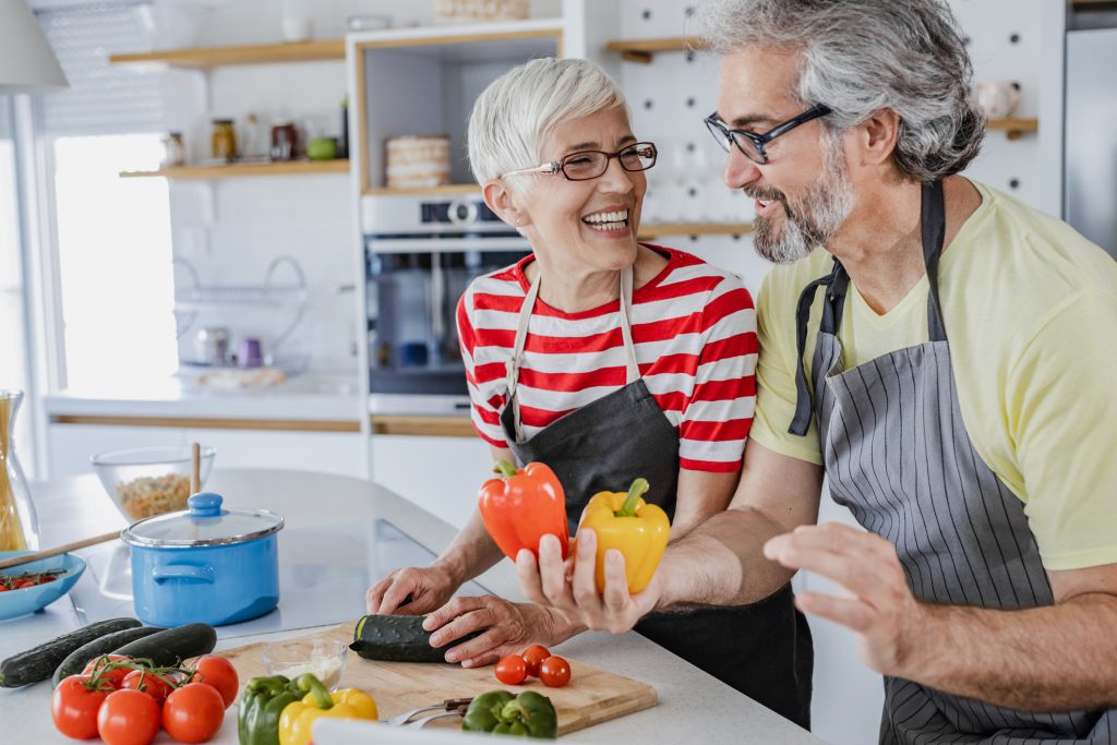 Senior woman and senior man are in the kitchen, they are cooking together